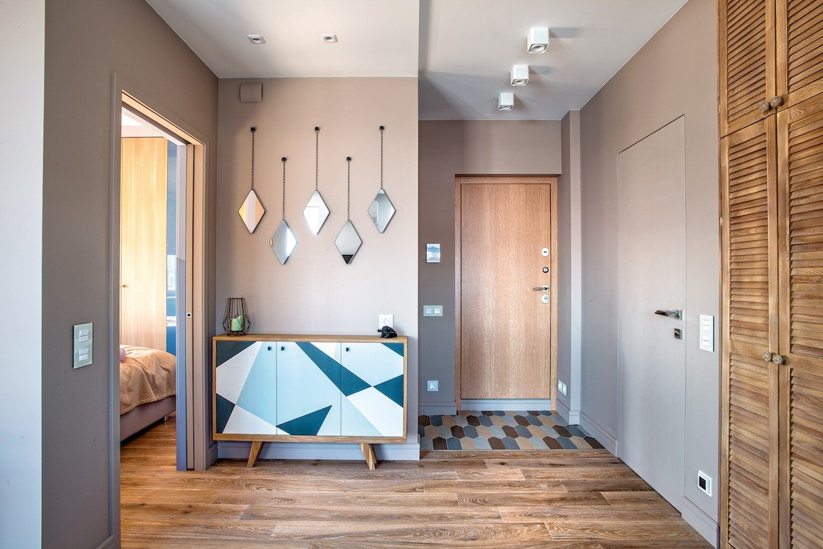 По левую руку от входа в квартиру оборудована вместительная гардеробная, которая скрывается за раздвижной зеркальной дверью. В ней помещается не только верхняя одежда, но и спортивный инв...