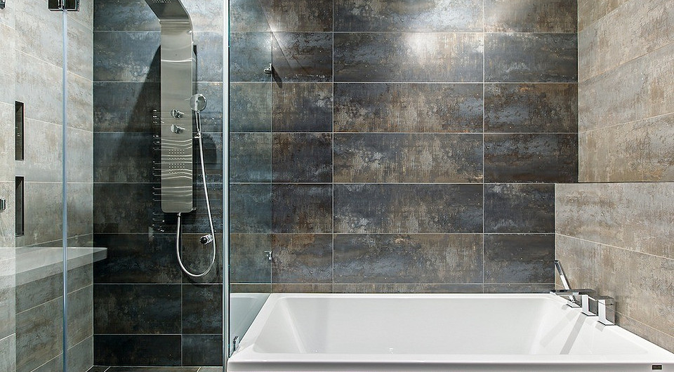 Оттенки и текстура ржаво-коричневой керамогранитной плитки в функционально строгой ванной создают эффект глубины и неоднородности пространства. В мокрой зоне для лучшего оттока воды соору...