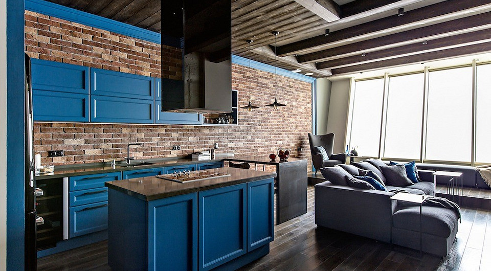 Строгий рисунок профилей на филёнках кухонных фасадов исполнили на заказ по эскизам автора проекта. Он подчёркивает укрупнённый ритм, наложенный на кирпичную кладку стены