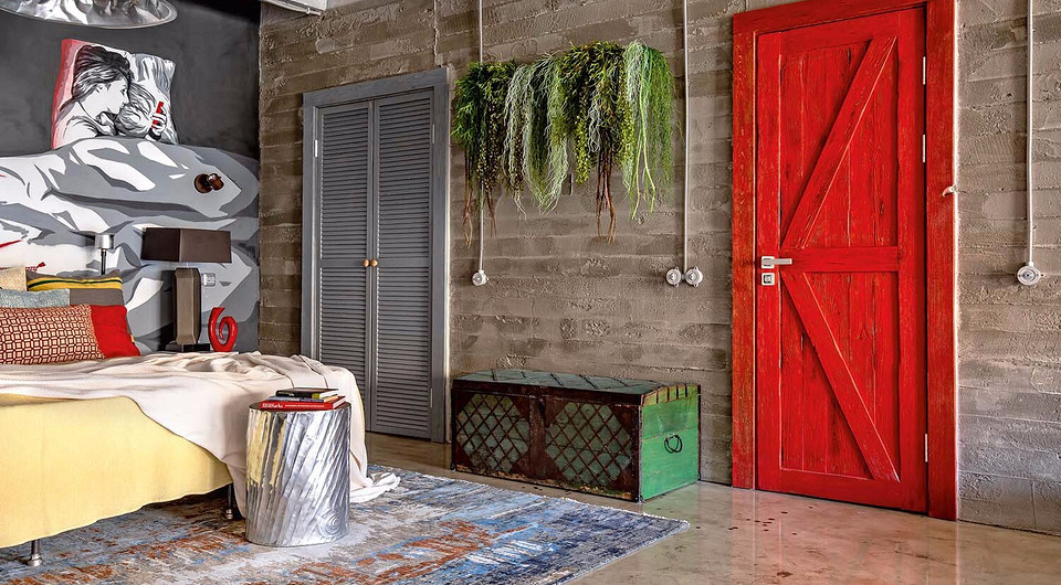 Каркас кровати сварили из труб отопления, в изголовье приклеили алюминиевые кружки — они служат подсвечниками для декоративных свечей. Освещает спальную зону люстра, изготовленная из стар...