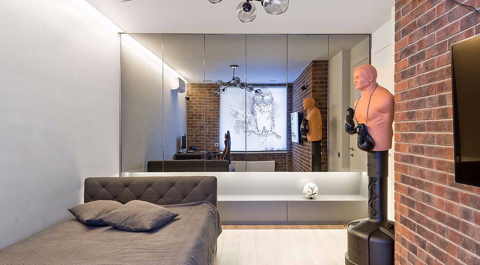 В комнате мальчика зеркальные навесные мебельные модули во всю ширину стены визуально расширяют границы помещения, одновременно решая проблемы хранения.