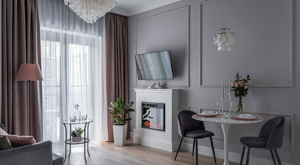 Молдинги на стенах и портал камина ненавязчиво уводят современный интерьер в сторону классики. В качестве основного освещения выступает люстра с полупрозрачными ракушками, в дополнение к...