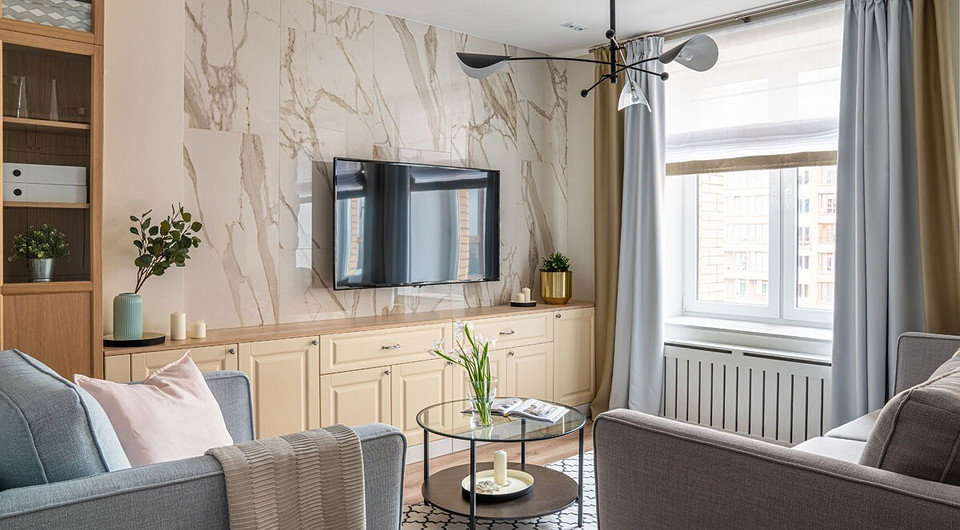 В кухне-гостиной по преимуществу задействованы стеллажи и серванты для посуды, под телевизором предусмотрена неглубокая система хранения с полками и ящиками.