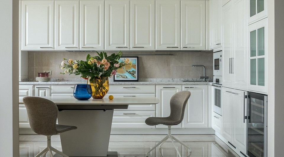 Вместительная кухня с большой поверхностью рабочей зоны была одним из пожеланий хозяйки. Справа размещены два встроенных холодильника, СВЧ, духовой шкаф и винный шкаф.