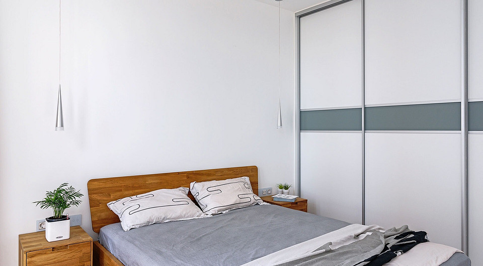 В комнате для сна помимо шкафа разместили лишь самое необходимое — кровать и маленькие тумбочки. Прикроватные светильники прикрепили к потолку, чтобы не уменьшать полезные поверхности