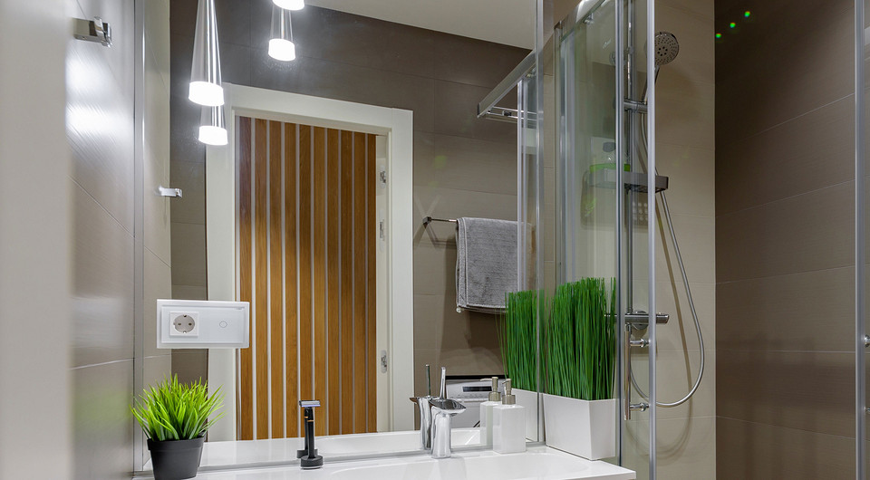 Душевой отсек сделали без бортика, но предусмотрели лёгкий уклон в сторону слива, расположенного у стены. От остального помещения душевой отсек закрыли раздвижными дверками из стекла.