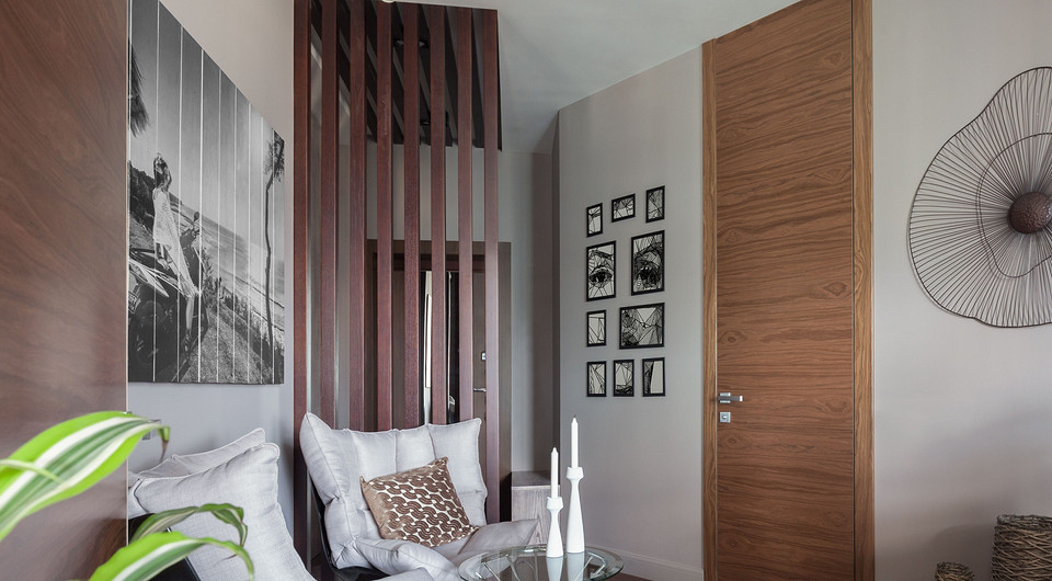 Реечная перегородка между гостиной и прихожей переходит в композицию на потолке. Линии перегородки продолжает отделка ниши, в которой располагается подсветка. Глубина ниши соответствует т...