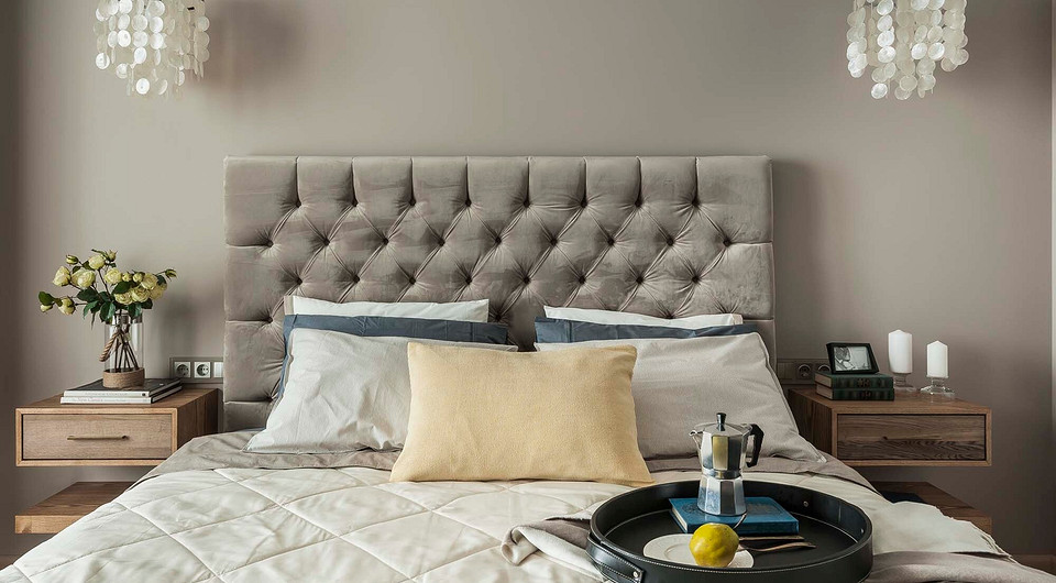 Умиротворяющая атмосфера создана за счёт текстиля — велюровой обивки изголовья кровати, ковра с этническими мотивами, светлых портьер, воздушного тюля