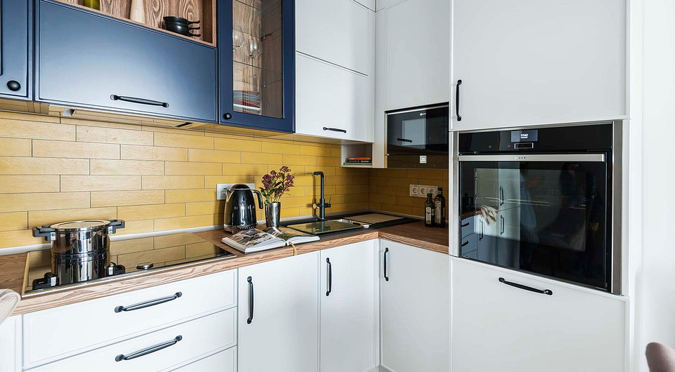 Фартук выложен горчично-золотистой плиткой, уложенной с горизонтальным смещением. Тёмно-сиреневая затирка создаёт эффектный контраст