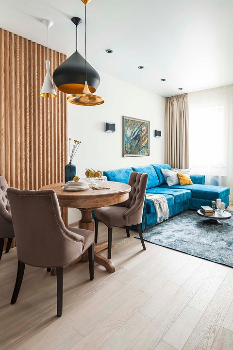 Зону гостиной акцентирует диван с обивкой насыщенного бирюзового цвета, напоминающий о скандинавском стиле