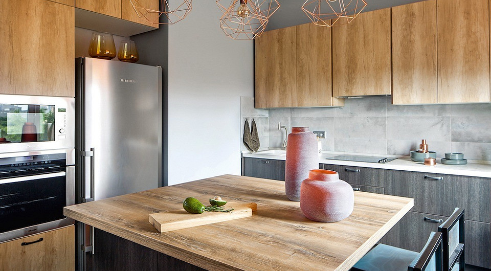 Оформление кухонной зоны построено на сочетании различных деревянных поверхностей натуральных оттенков. На такое решение дизайнера вдохновили разделочные доски, приобретённые заказчицей е...