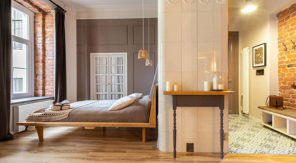 Рядом с кроватью — дверцы в довольно вместительный платяной шкаф. Их обрамляют деревянные панели с классической раскладкой из молдингов