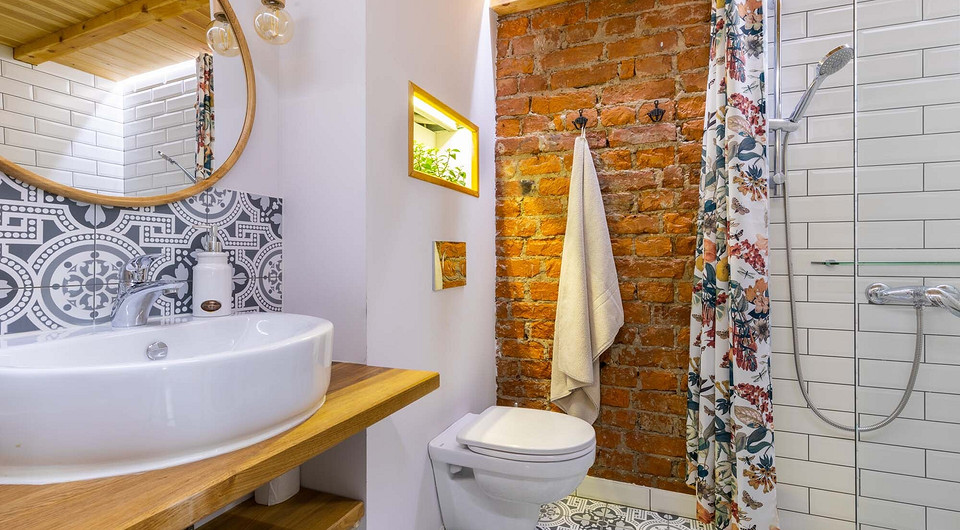 Необычный для ванной комнаты деревянный потолок одновременно служит основой для кровати. Душевая кабина позволила сэкономить площадь