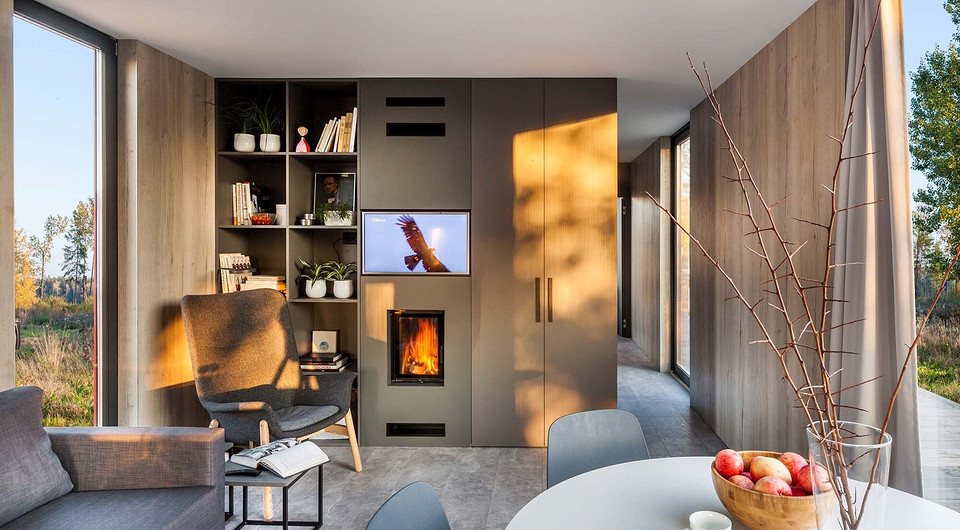 Естественные тона дерева в отделке стен, неброский цвет встроенной мебели, минимальный набор отдельно стоящих предметов и обилие света — всё это создаёт в микродоме ощущение простор...