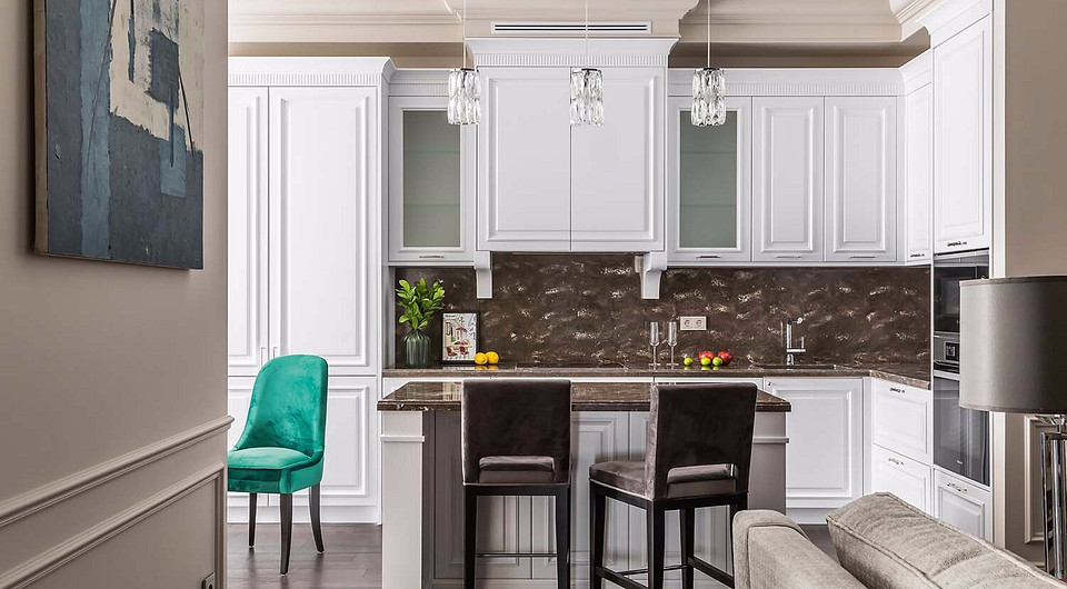 Рисунок текстуры столешниц и фартука из искусственного камня тактично украшает кухонную зону. Классические мотивы в дизайне кухонной мебели создают интересный стилистический контраст с со...