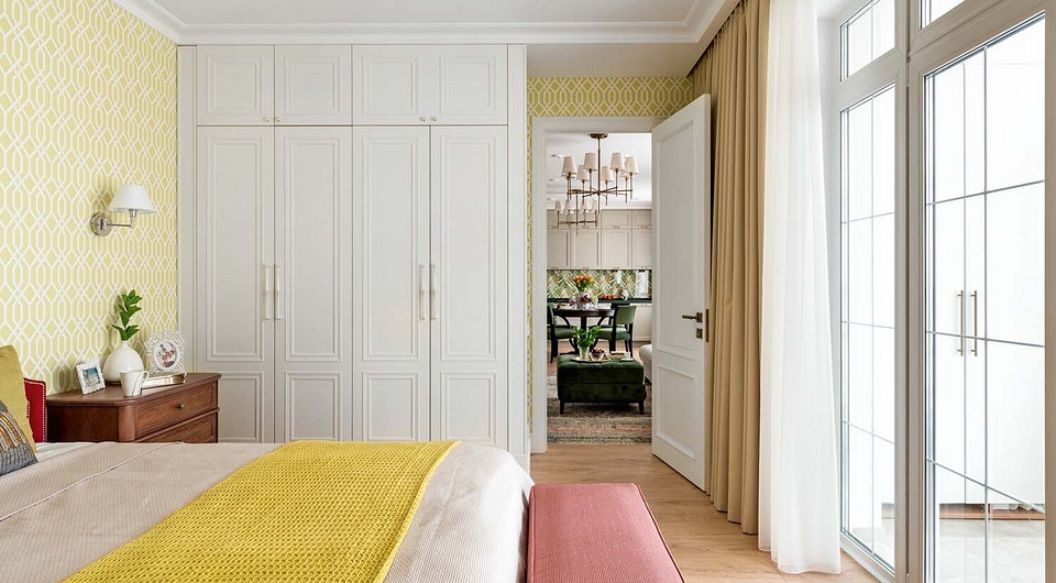 Вдоль дальней стены установлен большой встроенный шкаф с шестью секциями — для хозяйки, а на противоположной стене чуть меньшей вместимости — для хозяина.