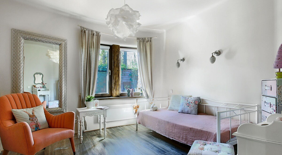 Дочь хозяев — будущая балерина, поэтому её комната решена в бело-розовой гамме и оборудована большим зеркалом. И даже подвесной светильник напоминает балетную пачку.