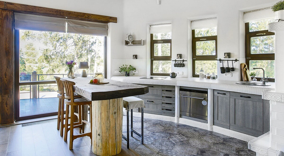 Несмотря на визуальное единство общего пространства, для отделки пола в нём выбраны разные материалы — в зоне между кухней и столовой уложен керамогранит, в гостиной — паркетная доска.