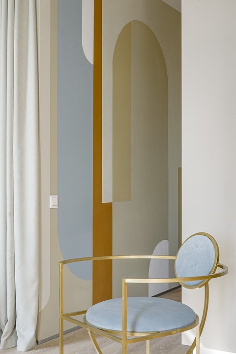 Форма стульев, прикроватных тумбочек и рисунок на стене в прихожей и между окнами перекликаются для создания визуальной игры форм и цвета в интерьере.