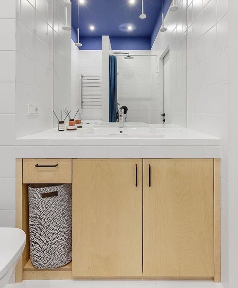 Еще один пример использования фанеры — для изготовления такого шкафа под раковину. Цвет натурального дерева отлично вписался в этот сине-белый интерьер ванной комнаты. 