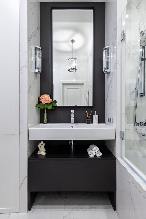 В ванной в качестве сценариев освещения использованы бра по бокам от зеркала, общая люстра и точечные светильники на потолке.