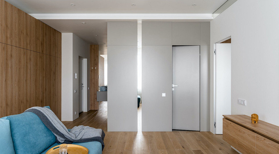 На фото отображен скрытый вход в ванную комнату из гостиной. Монтаж двери-невидимки, по словам дизайнера, — самый сложный этап в работе над всем проектом. При установке двери обратно...