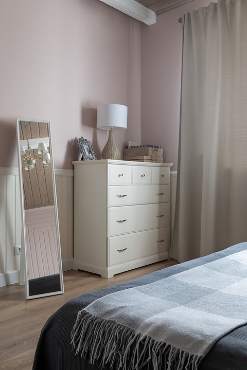 В спальне хозяев основная цветовая гамма — розовая, а кровать и шторы — оливковые. 