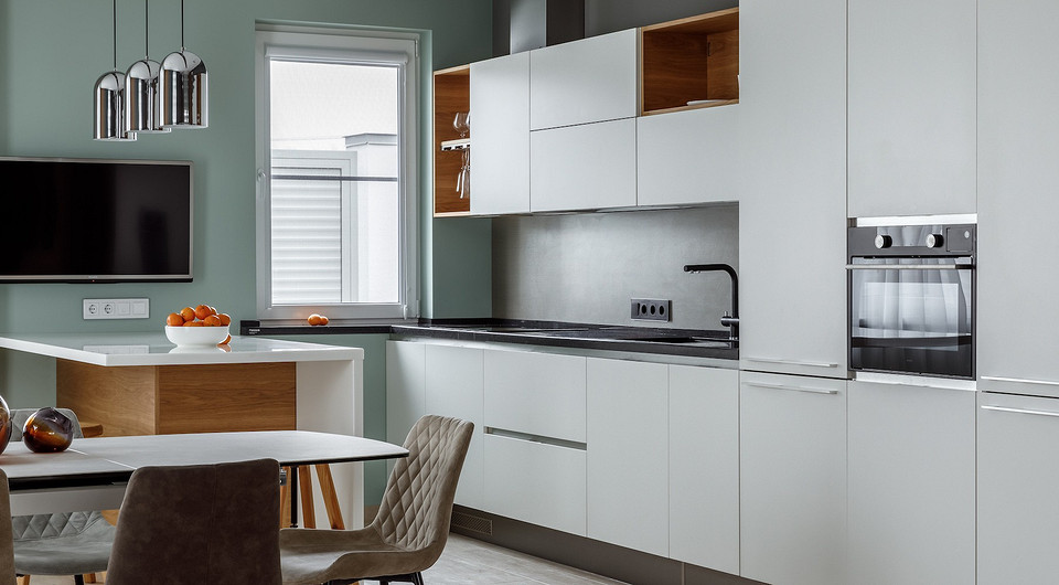 В кухне-гостиной основное место хранения — это кухонный гарнитур. Кроме основной линии мебели спроектирован остров с выкатными ящиками и полками.