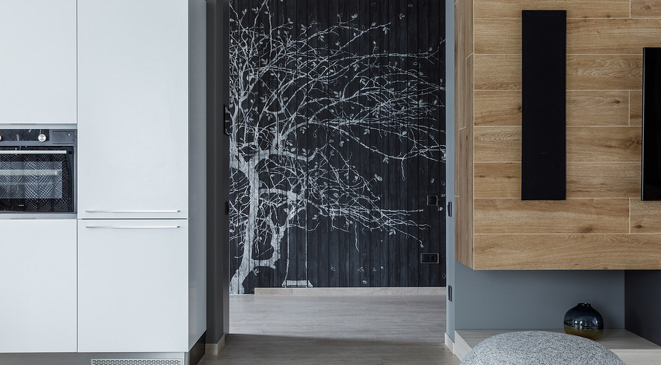 В кухне-гостиной в зоне телевизора стены отделаны тем же керамогранитом, что и пол.