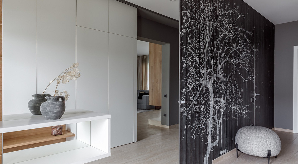 В коридоре использовали нестандартный декоративный прием — двери в ванную и гостевую комнаты скрыты за настенным панно. Для зрительного увеличения пространства часть стены во входной...