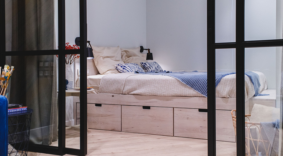 В спальне вместо кровати спроектировали большой подиум 2х2 метра из дерева. Под ним — выдвижные ящики, которые тоже можно использовать для хранения. Сбоку от подиума планируется поставить...