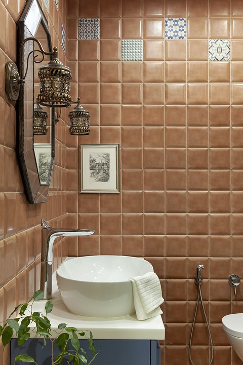 В отличие от светлой палитры большинства стен в квартире, ванная комната выделяется яркой — цвета рыжей глины — керамической плиткой с рельефной, выпуклой поверхностью и декором пэчворк....