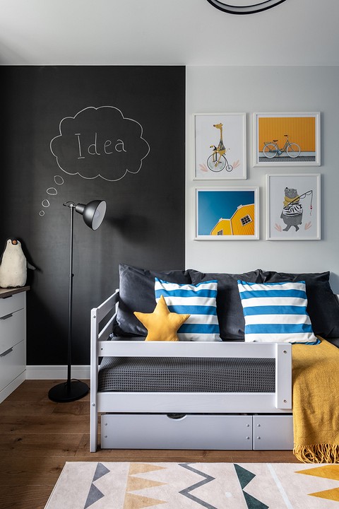 Часть стены в комнате ребенка окрашена черной грифельной краской — простор для фантазии и самовыражения.