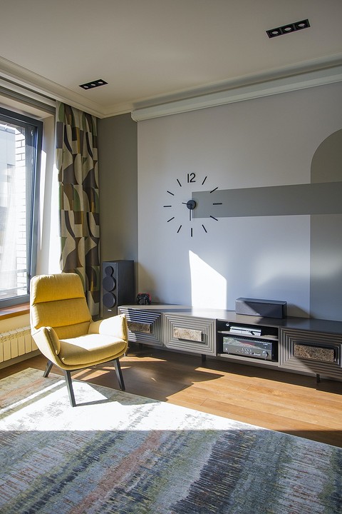 Плотные шторы, мягкая мебель, ковер поглощают звуки, а следовательно, улучшают акустику помещения гостиной.