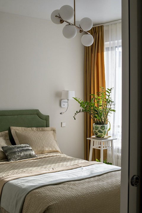 В спальне свет разделен на два сценария — потолочная люстра и бра в зоне кровати для чтения.
