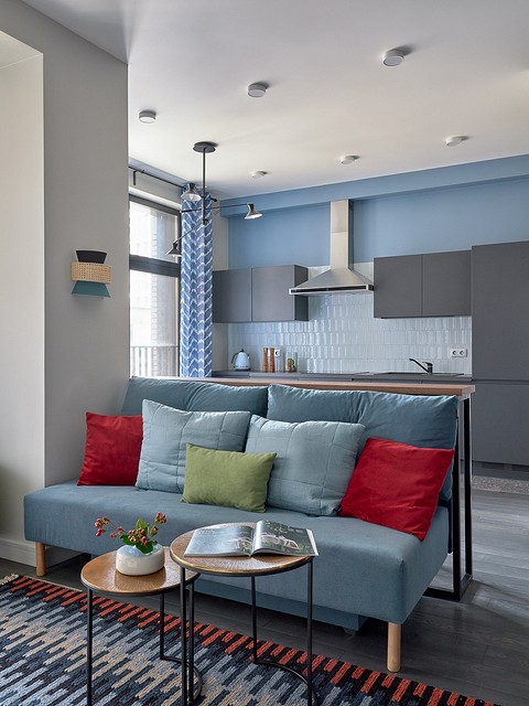 Стены оформили английской краской нейтрального оттенка в гостиной и светло-голубого — в зоне спальни и кухни.