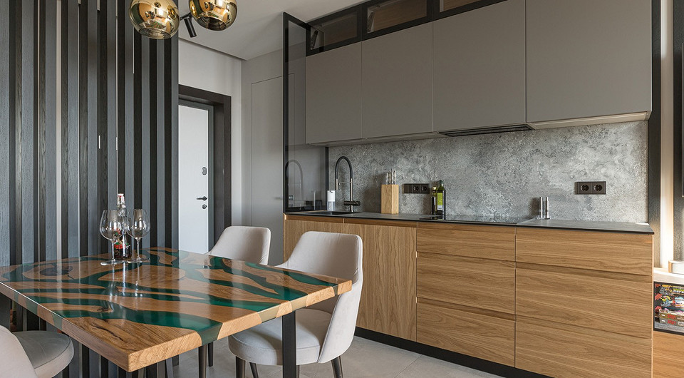 Оригинальным украшением кухни-гостиной является «стол-река», выполненный на заказ из натурального дерева. Именно такой дизайн был принципиально важен для клиента.