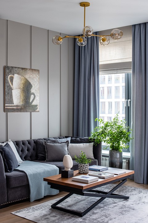 Однотонный текстиль и массивный диван с блестящими клёпками, олицетворяющий баланс комфорта и хорошего вкуса, позаимствованы из американского классического стиля.