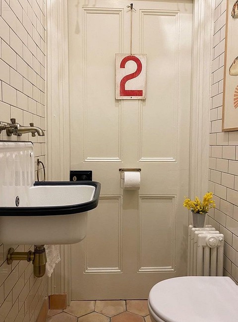 Глубокую раковину в ретростиле в этом санузле поддерживают и другие интересные детали: постер на стене, замок на двери, который мало напоминает привычную туалетную защелку, кольцо-держате...