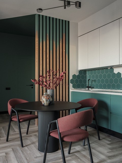 Основной оттенок прихожей, кухни и гостиной — сложный зеленый. Он «начинается» в прихожей, где этим цветом окрашены стены, встроенная мебель и даже потолок, и продолжается в кухне-гостино...